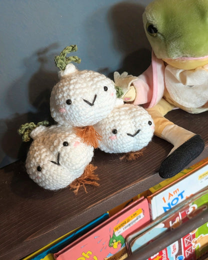 Crochet garlic plushies on a shelf