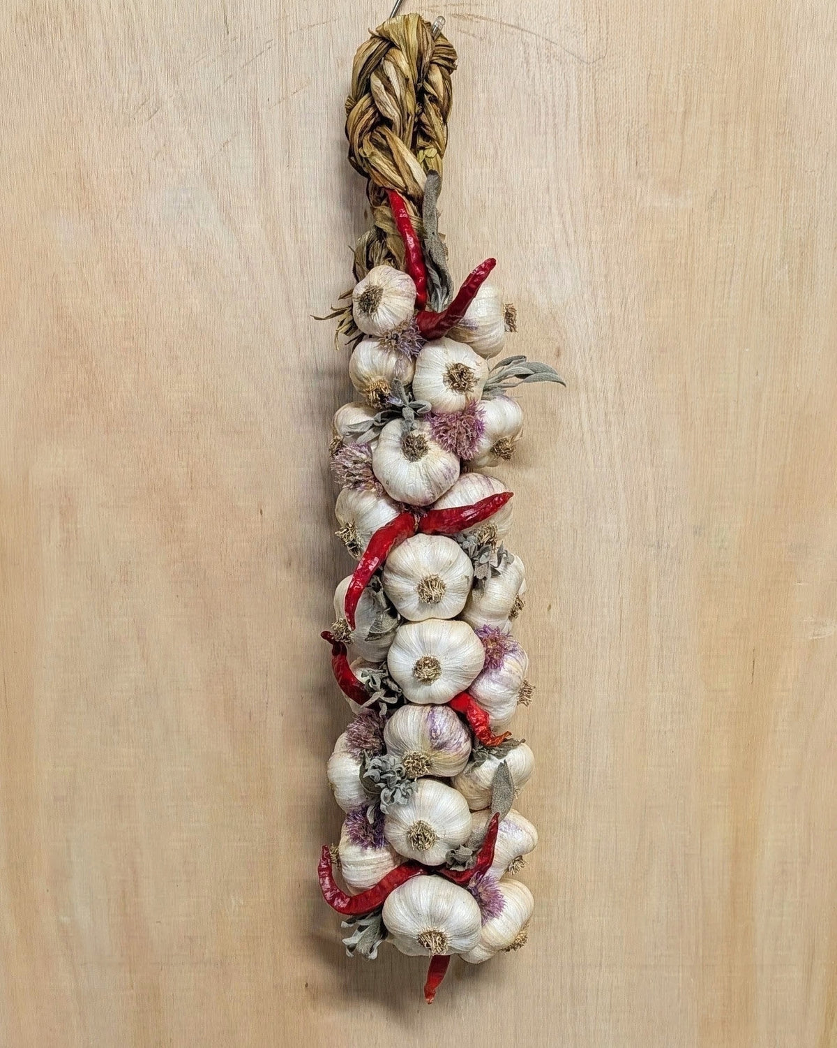Large pepper and herb garlic braid on wood