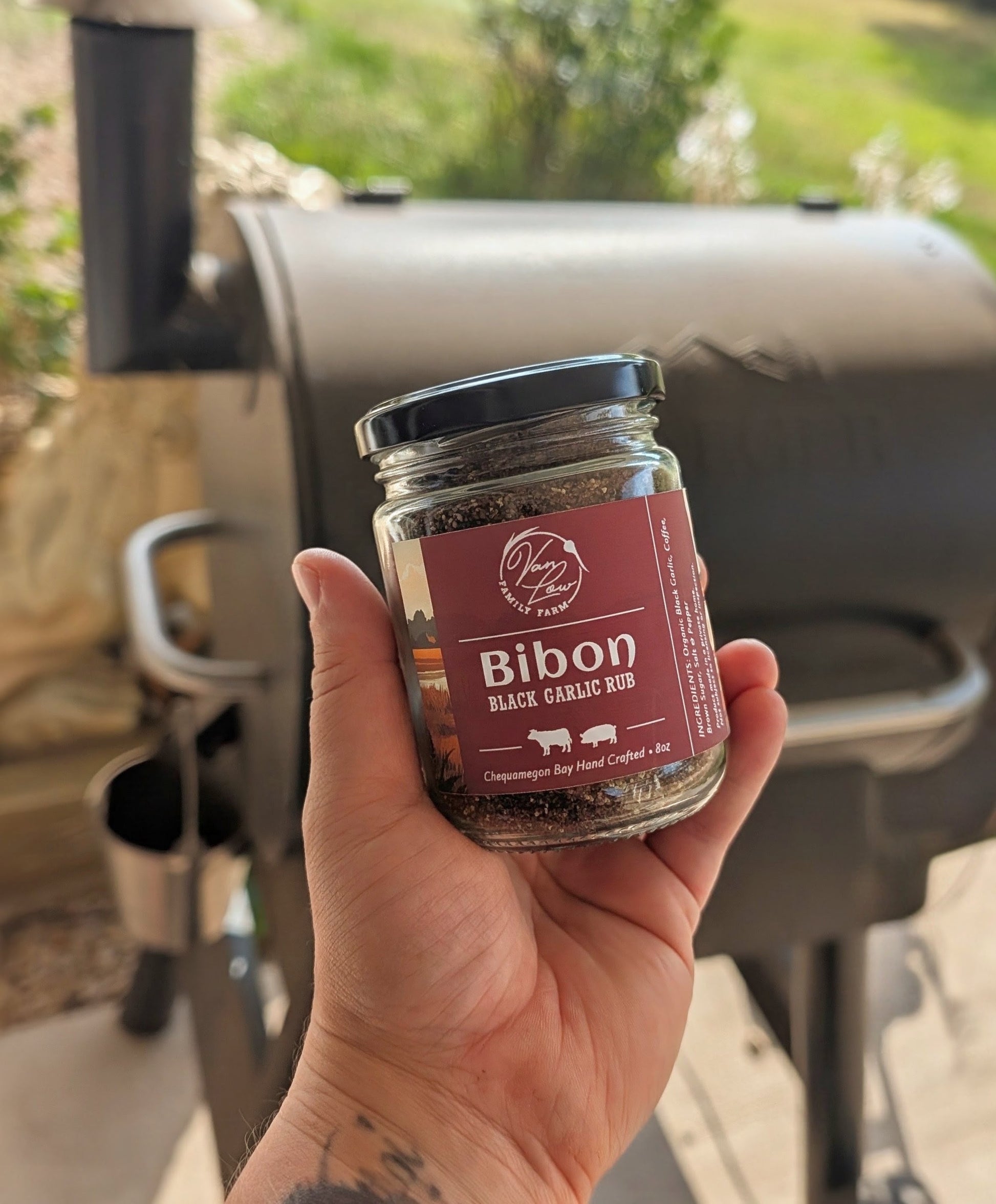 Bibon black garlic rub jar from Van Low Family Farm, Marengo Wisconsin, held by the smoker