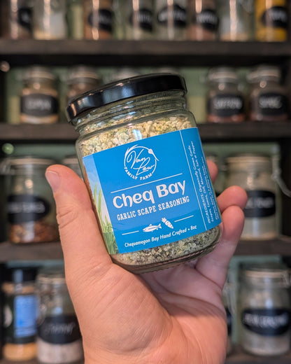 Cheq Bay garlic scape seasoning jar from Van Low Family Farm, Marengo Wisconsin, held in hand