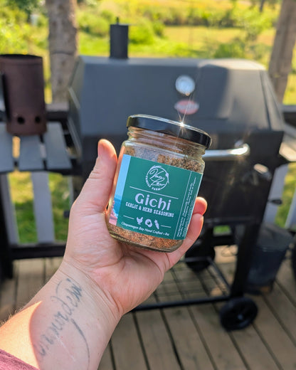 Gichi garlic and herb seasoning jar from Van Low Family Farm, Marengo Wisconsin, held over the grill